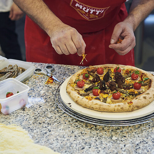 Mann bereitet eine Pizza zu