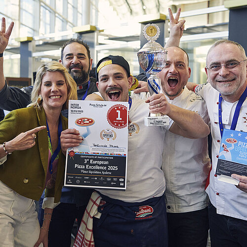 Sieger der European Pizza Excellence 2025 jubelt mit drei Männern und einer Frau um seine Erstplatzierung vor der Kamera.