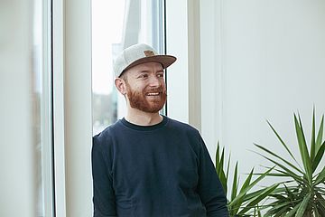 RECUP Gründer Florian Eckert steht vor einem Fensterund lächelt