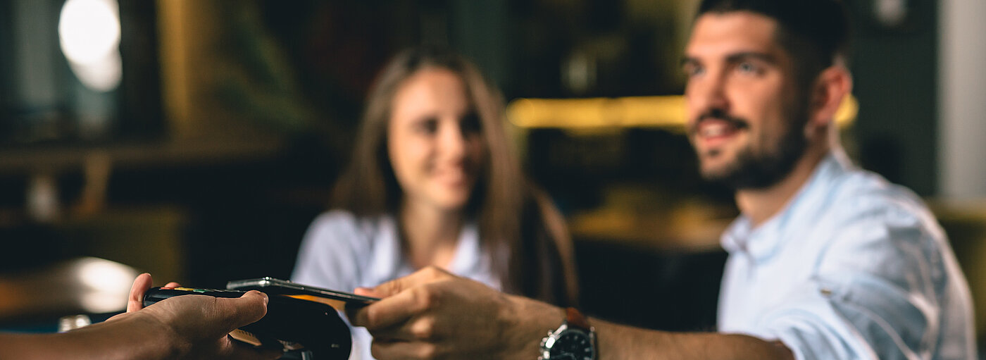 Mann bezahlt Essen mit dem Smartphone 