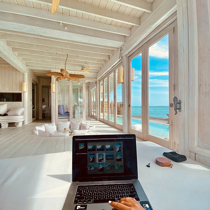 Im Vordergrund Laptop-Bildschirm, in Hintergrund blaues Meer