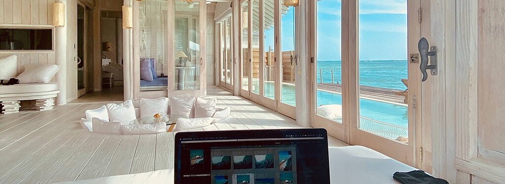 Im Vordergrund Laptop-Bildschirm, in Hintergrund blaues Meer